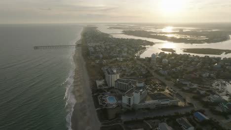 Drone-shot-of-beach-town-at-sunset