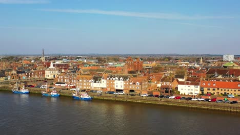 Aerial-view-of-Kings-Lynn-riverfront-to-the-estuary-and-wind-turbines-on-the-River-Great-Ouse,-Kings-Lynn,-Norfolk,-UK