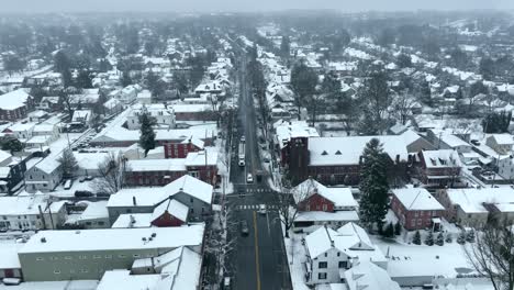 Aerial-pull-back-reveal-over-small-town-in-America-street-during-snow-storm