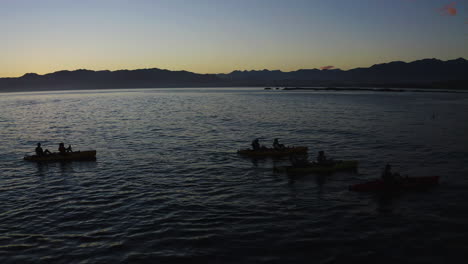 Kayaking-in-the-ocean-at-Kiakoura-New-Zealand-during-a-beautiful-sunrise-with-friends
