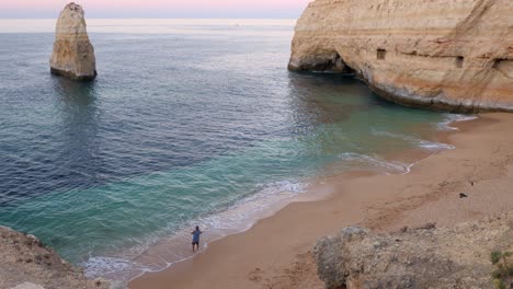 Ein-Einzelner-Fischerangler-An-Einem-Perfekten-Verlassenen-Paradies-Idyllischen-Strand-An-Der-Algarve-Bei-Sonnenaufgang