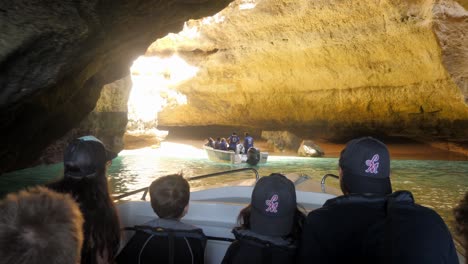 Point-of-view-footage-of-a-small-boat-with-five-passengers-entering-a-sea-cave-in-the-Algarve,-Portugal