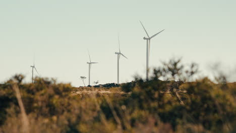 Die-Windturbinen-In-Bewegung-Und-Nutzen-Die-Kraft-Des-Windes,-Um-Saubere-Energie-In-Den-Bergen-Bereitzustellen