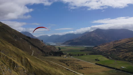 Parapente-En-Wanaka-Nueva-Zelanda-A-Través-De-Las-Montañas-Y-Colinas-Con-Vistas-A-Un-Hermoso-Día-De-Verano-Cerca-Del-Valle
