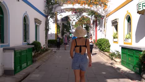 Woman-rear-view-walk-through-streets-of-white-town-old-city-in-Callao-Beach,-Gran-Canaria,-canary-islands,-Spain