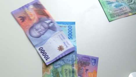 Tirando-Billetes-De-Banco-De-Rupias-Indonesias-En-Cámara-Lenta,-Dinero-O-Efectivo-Cayendo