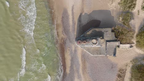 Top-view-of-an-abandoned-WW2-arrowhead-shaped-bunker-on-the-Baltic-Sea-beach