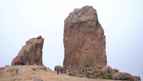 Hiking-group-ascending-to-Roque-Nublo-duroing-a-misty-morning-in-Gran-Canary-Island,-Spain