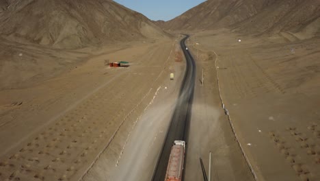 Truck-driving-uphill-a-narrow-paved-road-through-the-desert-mountains