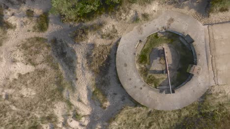 An-aerial-view-of-a-defensive-WW2-turret-with-preserved-cannon-on-the-coast-of-the-Baltic-Sea