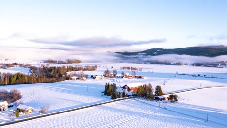Flying-over-the-small-vilage-of-Kroderen,-Norway-during-the-winter