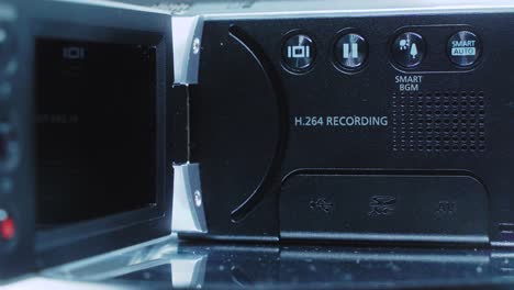 Nahaufnahme-Einer-Videokamera,-Silberner-Camcorder-Auf-Einem-Drehständer,-Studiobeleuchtung,-4k-Video-In-Zeitlupe,-Offener-Bildschirm,-Menütasten