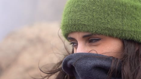 Cute-woman-protecting-herself-from-the-wind-on-a-winter-cold-morning-at-the-mountain