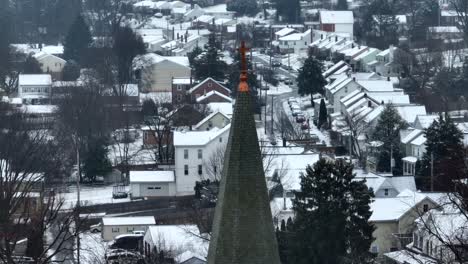 Church-steeple-in-front-of-snow-covered-houses-in-American-town