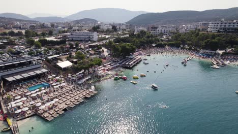 Aerial-over-exotic-crowded-beach-Resort-in-Albania,-Ksamil-Islands