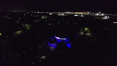 Aerial-view-dolly-in-of-the-galileo-galilei-planetarium-with-the-globe-lights-off,-the-paths-are-demarcated-when-the-front-of-the-structure-is-illuminated