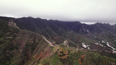 Aerial-wide-landscape-of-mountain-road-on-top-of-a-green-ridge,-Tenerife