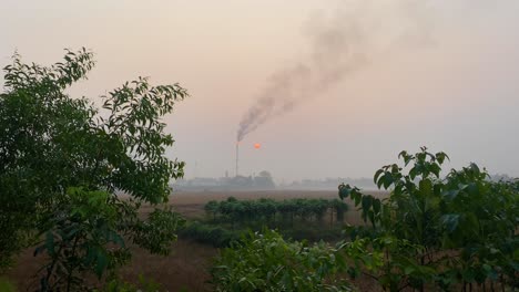Establisher-static-shot-of-Gas-burning-tower-plant-polluting-rural-countryside