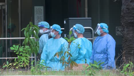 Health-workers-wear-PPE-suits-are-seen-standing-vigilant-outside-a-building-placed-under-lockdown-after-a-large-number-of-residents-tested-Covid-19-Coronavirus-positive