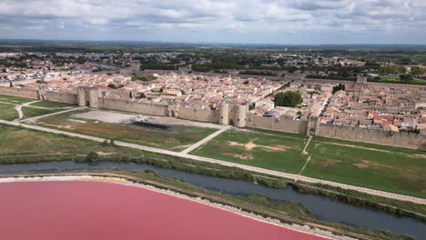 Drone-shot-of-an-old-city-in-France-with-pink-ocean-and-a-river