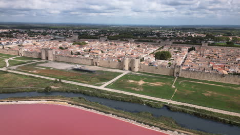 Drone-shot-of-a-old-town-in-France-with-a-pink-sea-in-front-of-it