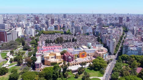 Dolly-in-aerial-view-of-the-Recoleta-cultural-center-with-the-cemetery,-residential-buildings-on-a-sunny-day,-green-recreational-areas
