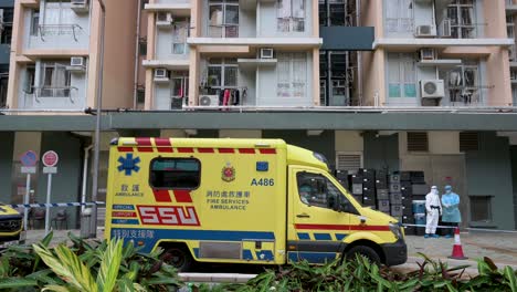 An-ambulance-and-health-workers-prepare-for-a-mass-number-of-Covid-19-Coronavirus-positive-cases-outside-a-public-housing-building-complex-placed-under-lockdown