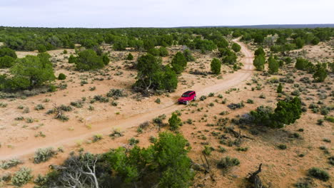 Roter-Jeep-Offroading-Mit-Dichten-Wacholderbäumen-Auf-Der-Wilden-Nahen-Weißen-Tasche,-Utah-Usa