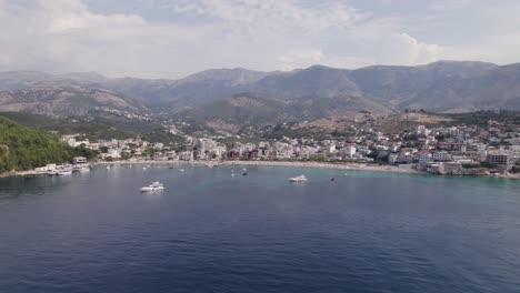 Aerial-approaching-sandy-beach-against-mountains,-Himare,-Albania