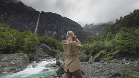 Blond-female-nature-photographer-stepping-into-frame-at-Rob-Roy-glacier-valley