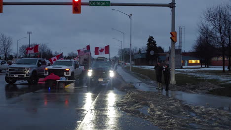 Freedom-Convoy-Protest,-Windsor,-Ontario,-Canada,-Canadian-Flags-Waving,-Trucks-and-People-Expressing-their-Discontent