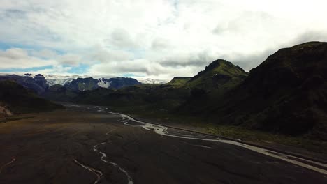 Vista-Aérea-Del-Paisaje-De-Un-Río-Que-Fluye-A-Través-De-Un-Valle,-En-El-área-De-Fimmvörðuháls,-Islandia