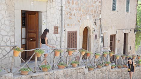 People-are-going-on-a-sidewalk-at-valldemossa,-highest-village-at-mallorca