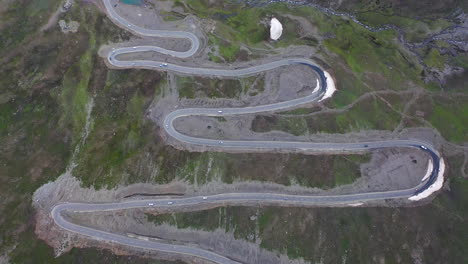 Top-down-aerial-view-of-cars-driving-hairpin-bends-along-the-Karakoram-highway