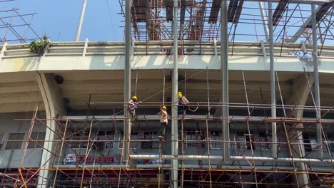 Construction-working-installing-scaffolding-on-building-job-site