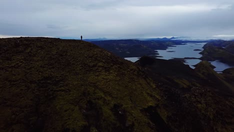 Aerial-drone-landscape-view-of-a-silhouette-of-one-person,-standing-on-top-of-a-mountain,-in-the-Iceland-highlands
