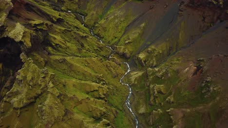 Luftaufnahme-über-Einen-Fließenden-Fluss-Und-Natürliche-Texturen-Und-Muster-Des-Isländischen-Geländes