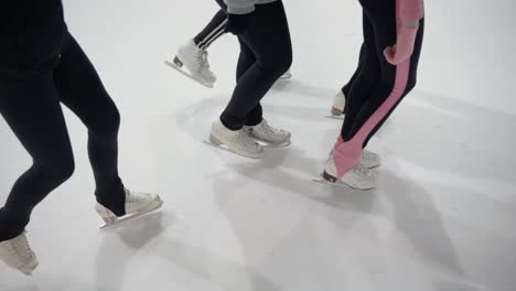 Eiskunstläuferinnen-Auf-Dem-Eis,-Die-Sich-In-Zeitlupe-Sanft-Nach-Vorne-Bewegen,-Indoor-Sportarena
