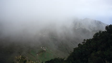 Zeitraffer-Von-Nebel,-Der-über-Eine-Bergkette-Fließt,-Mit-Dem-Ozean-Im-Hintergrund