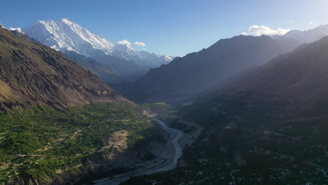 High-aerial-drone-view-of-the-sun-setting-over-the-beautiful-mountain-landscape-of-Hunza-Valley,-Pakistan
