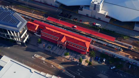 Aerial-view-of-a-Train-At-The-South-Brisbane-Station-near-South-Bank,-Brisbane-City,-Queensland,-Australia-during-sunset