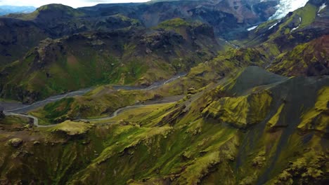 Aerial-landscape-view-of-a-river-flowing-through-mountain-valleys,-in-the-FimmvÃ¶rÃ°uhÃ¡ls-area,-Iceland