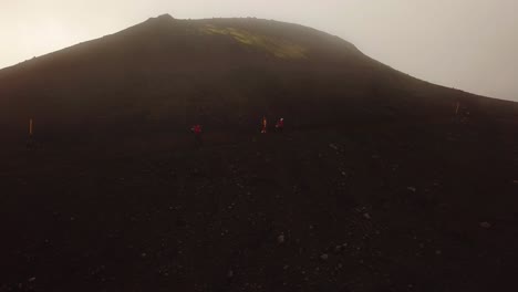 Vista-Aérea-Del-Paisaje-De-Personas-Caminando-Por-Un-Sendero-De-Montaña,-En-Un-Día-De-Niebla,-área-De-Fimmvörðuháls,-Islandia
