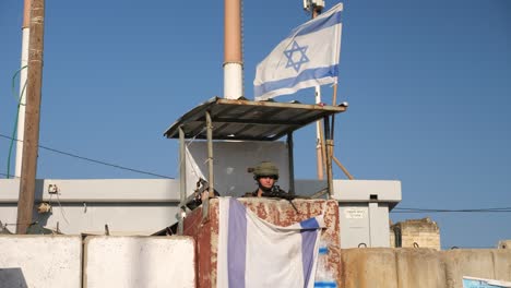 IDF-soldier-in-security-tower-waves-Israel-flag-and-make-kiss-gesture
