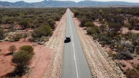 Luftaufnahme-Eines-Geländewagens,-Der-Auf-Einer-Langen-Und-Geraden-Straße-Durch-Australiens-Unversöhnliches-Outback-Fährt