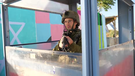 Touch-looking-Israeli-soldier-holding-rifle-in-checkpoint-cabin