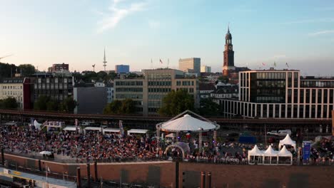Hamburg-Harbour-at-Hamburg-Cruise-Days-festival-with-crowd-of-people-and-Michel-in-the-background-at-golden-hour
