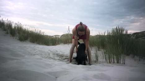 Zeitlupe-Einer-Jungen-Frau,-Die-Mit-Ihrem-Hund-Am-Strand-Spielt