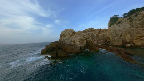 FPV-Drone-flying-over-the-ocean-and-around-cliffs-in-Mallorca-and-flying-low-over-nearby-trees