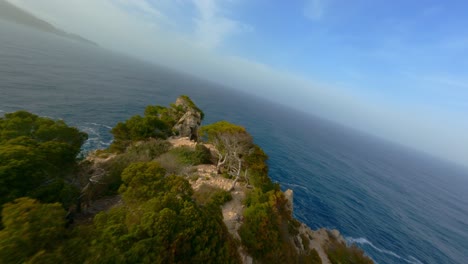FPV-Drone-flying-in-Mallorca-flying-low-over-trees-and-diving-down-the-hills-at-the-shore-flying-across-the-ocean-in-the-evening-sun